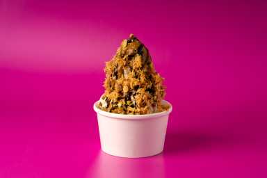 The dubai ice cream sundae in front of a pink background